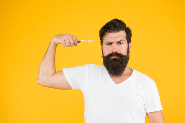 mint paste healthy teeth gggguard freshness teeth whitening procedure bearded man hold toothbrush yellow background hipster serious strict face cares hygiene brush teeth fresh breathe